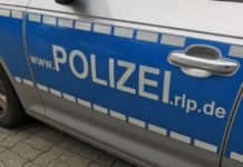 Mann bedroht Frau mit einer Gartenhacke vor Supermarkt