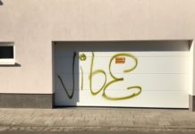 Hauswand und Garagentor mit Farbe besprüht