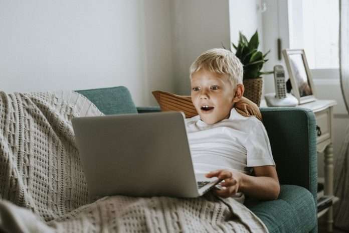 Young boy watching videos on his laptop